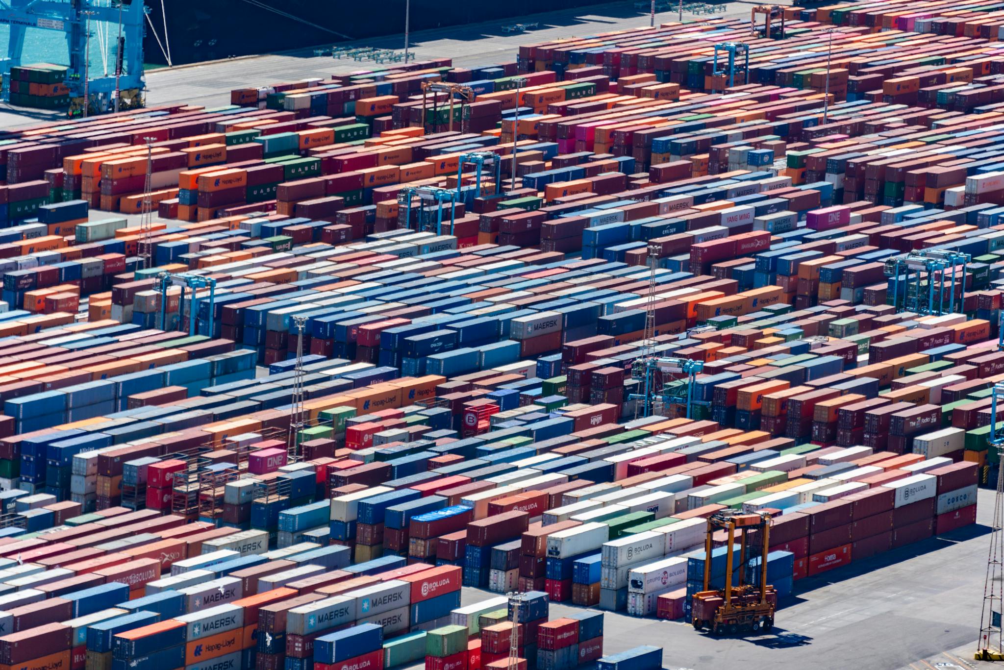 A bustling port with colorful cargo containers, aerial view showcasing global trade.