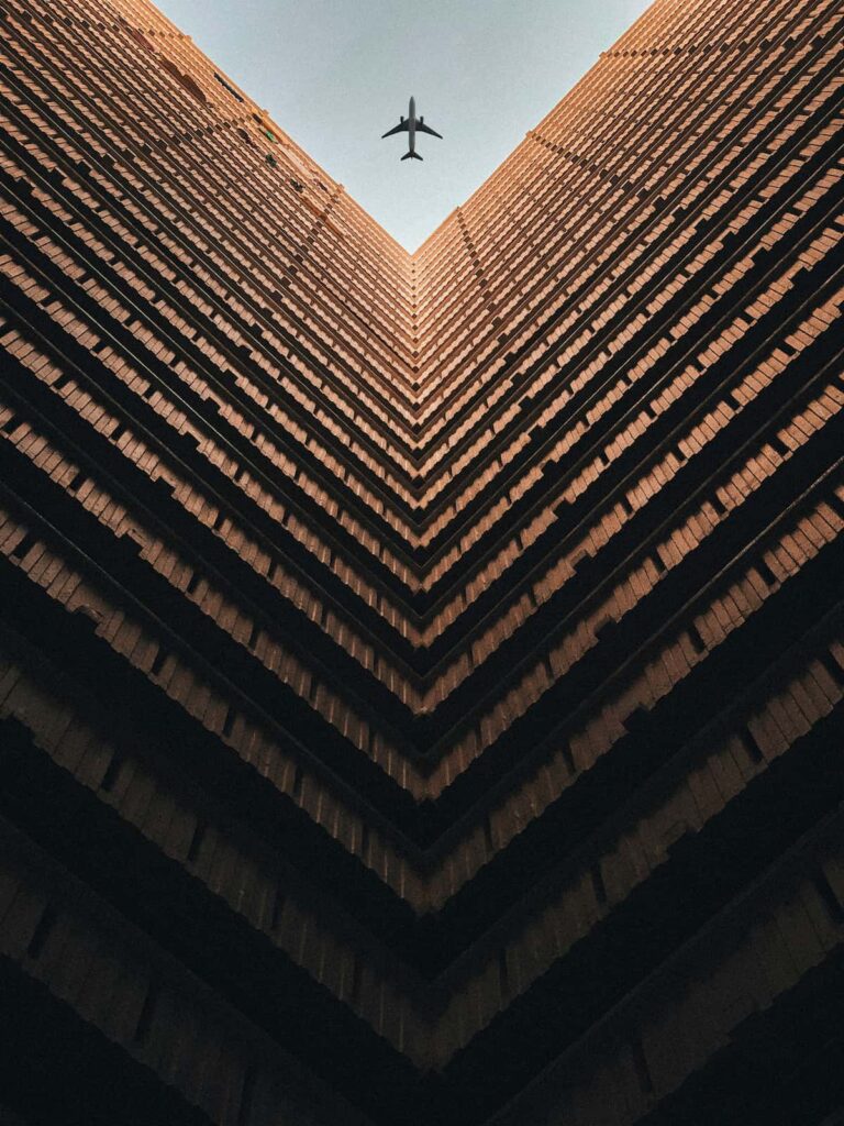 Archticetural HIghrise Looking Upwards Plane Flying Over